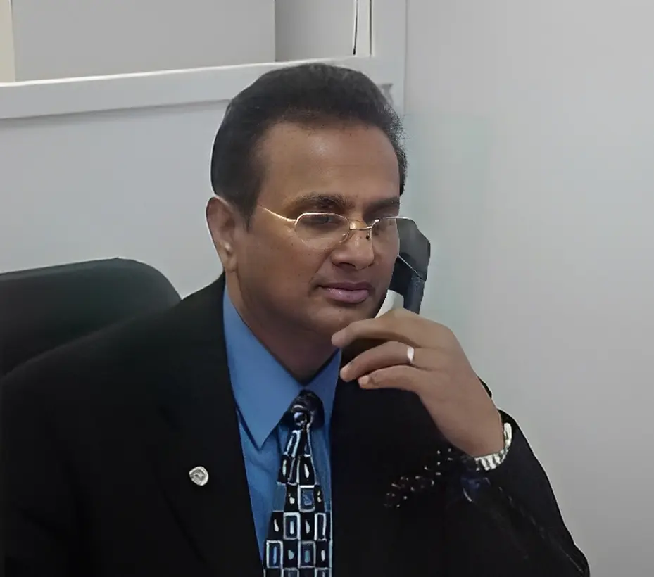 Man in suit sitting at a desk.